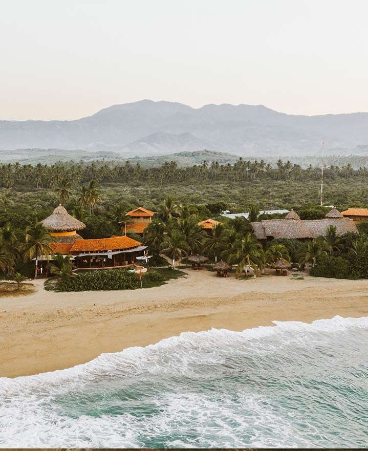 An aerial view of a beach with mountains in the background.
