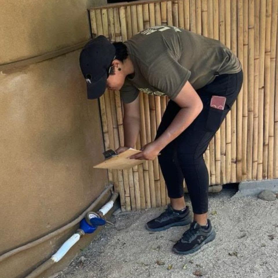 A man wearing a hat and holding a piece of paper