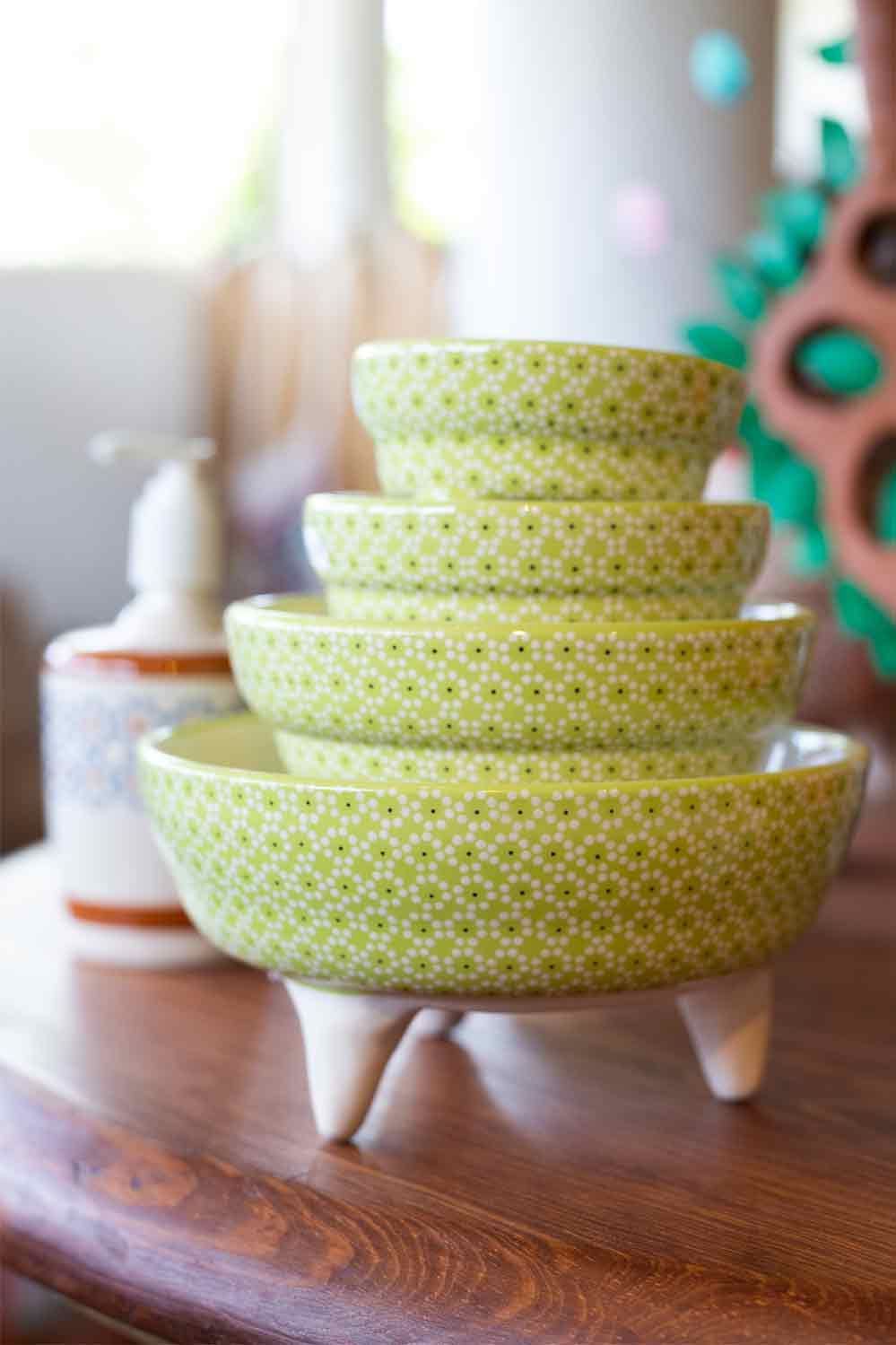A stack of green bowls sitting on top of a wooden table.