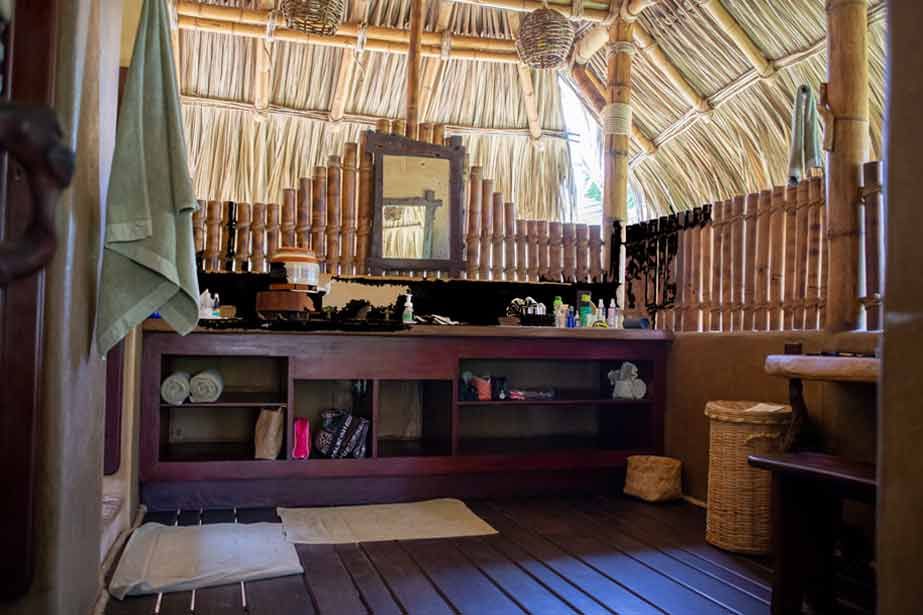 A bathroom with a wooden floor and a bamboo roof