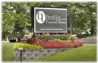 Sign for David Lee Funeral Home with colorful flowers in front.
