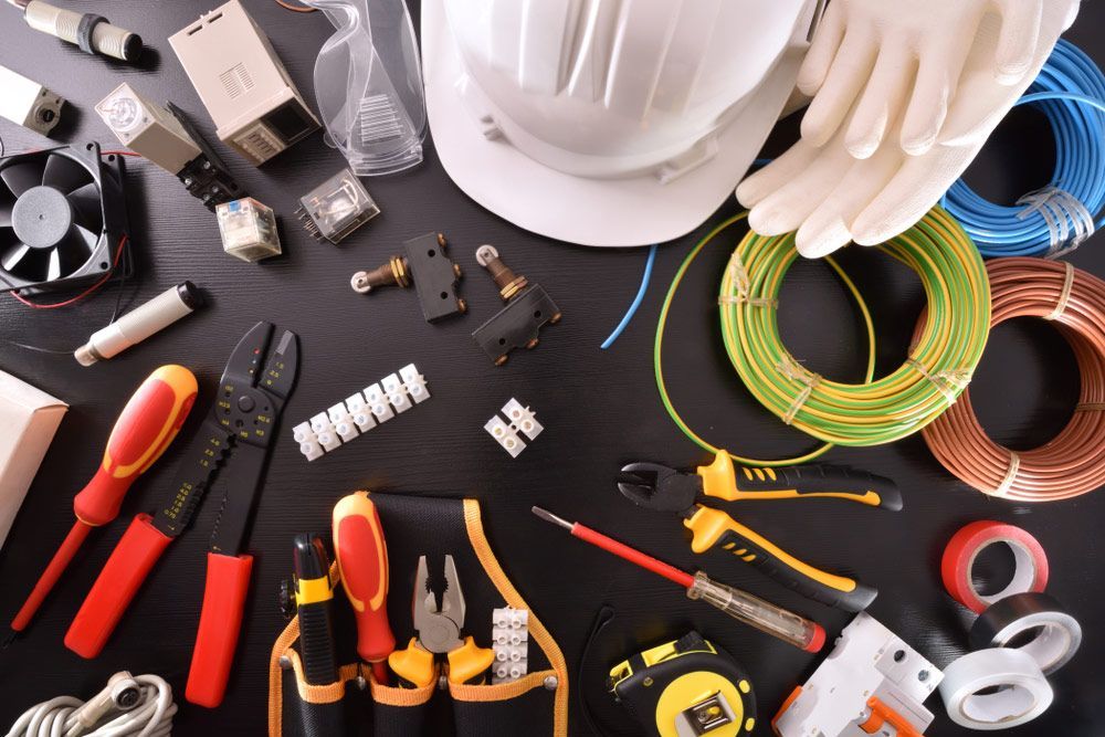 A Hard Hat Is Sitting On Top Of A Table Surrounded By Electrical Tools — Wylec In Newcastle, NSW
