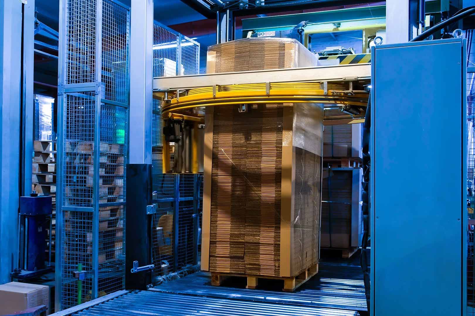 A Large Stack Of Cardboard Boxes Is Being Wrapped In Plastic In A Factory — Wylec In Lake Macquarie, NSW
