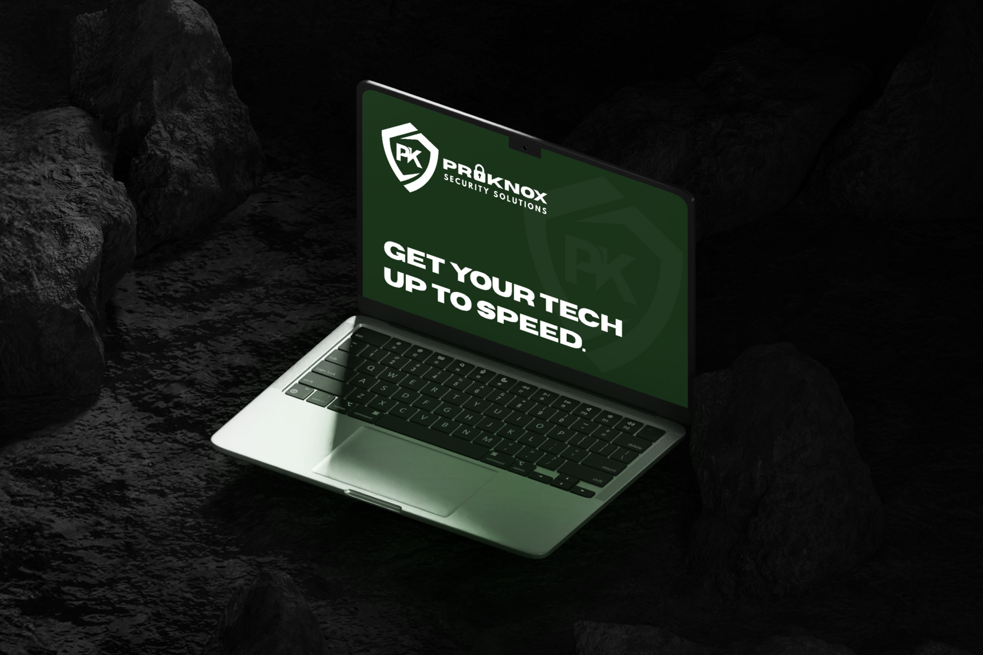 Silver laptop on black textured surface; screen displays text, 