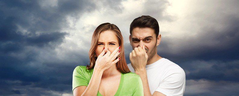 A man and a woman are covering their noses with their hands.
