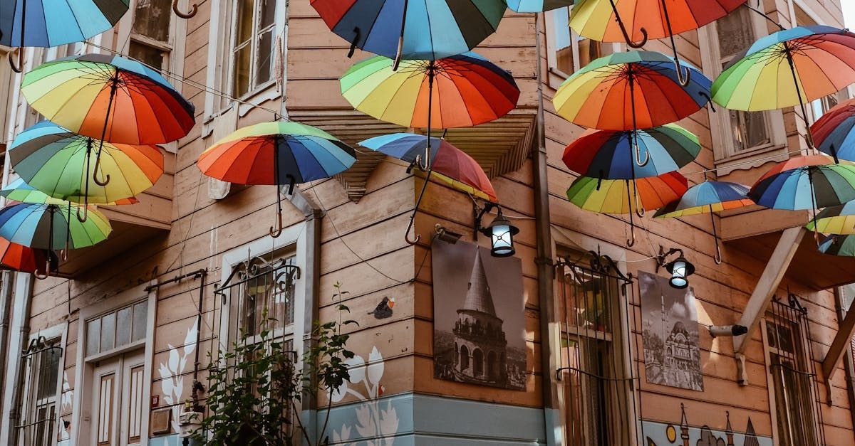 A bunch of colorful umbrellas are hanging from the ceiling of a building.