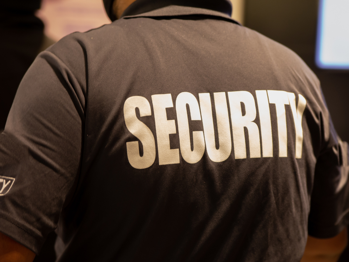 Security guard wearing a gray shirt with 