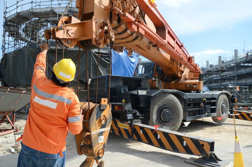 A Construction Worker Is Working on A Crane at A Construction Site — Linmar Cranes & Haulage in Julia Creek, QLD