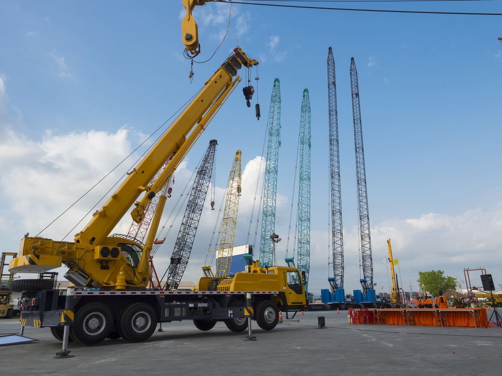 A Yellow Crane is Sitting on Top of a Truck at a Construction Site— Linmar Cranes & Haulage in Cloncurry, QLD