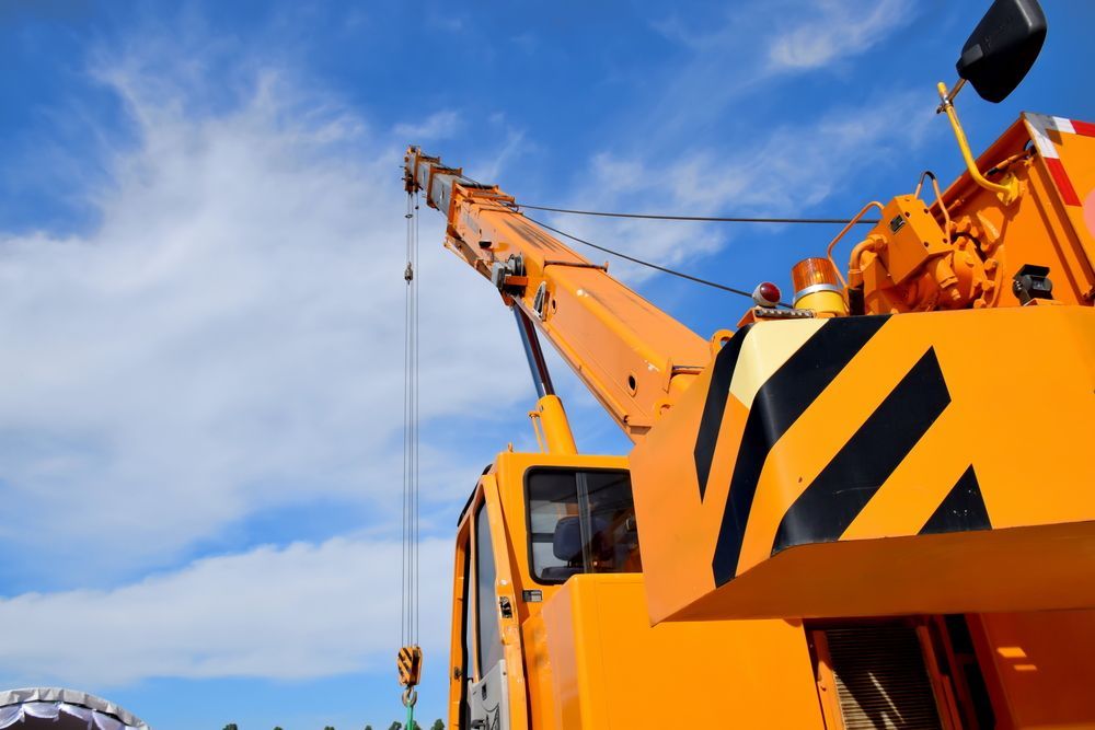 A Yellow Crane With a Blue Sky in the Background— Linmar Cranes & Haulage in Cloncurry, QLD