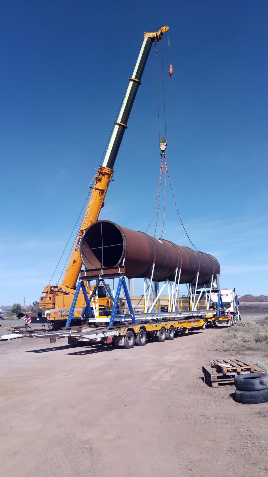 A Large Pipe Is Being Lifted by A Crane on A Trailer — Linmar Cranes & Haulage in Karumba, QLD