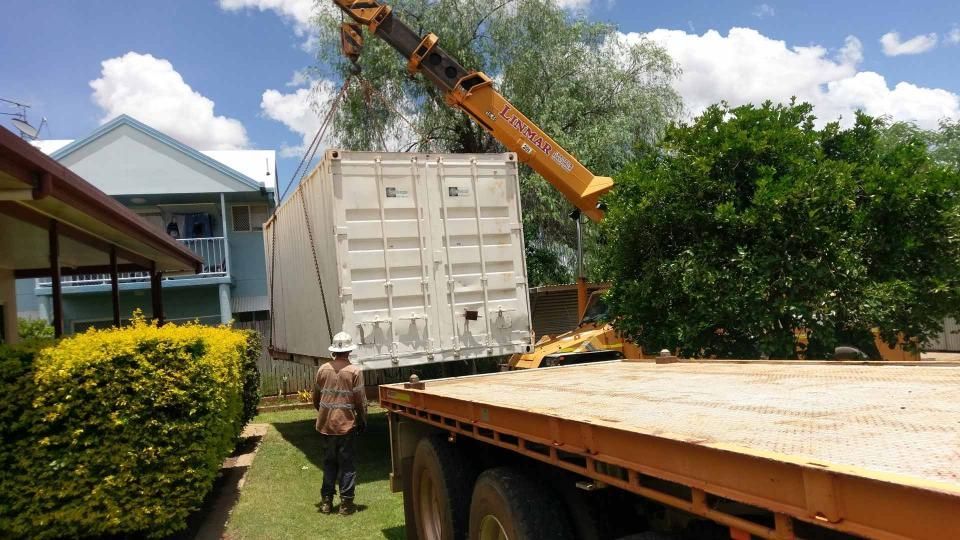 A Man is Standing Next to a Truck That is Being Lifted by a Crane — Linmar Cranes & Haulage in Kalkadoon, QLD