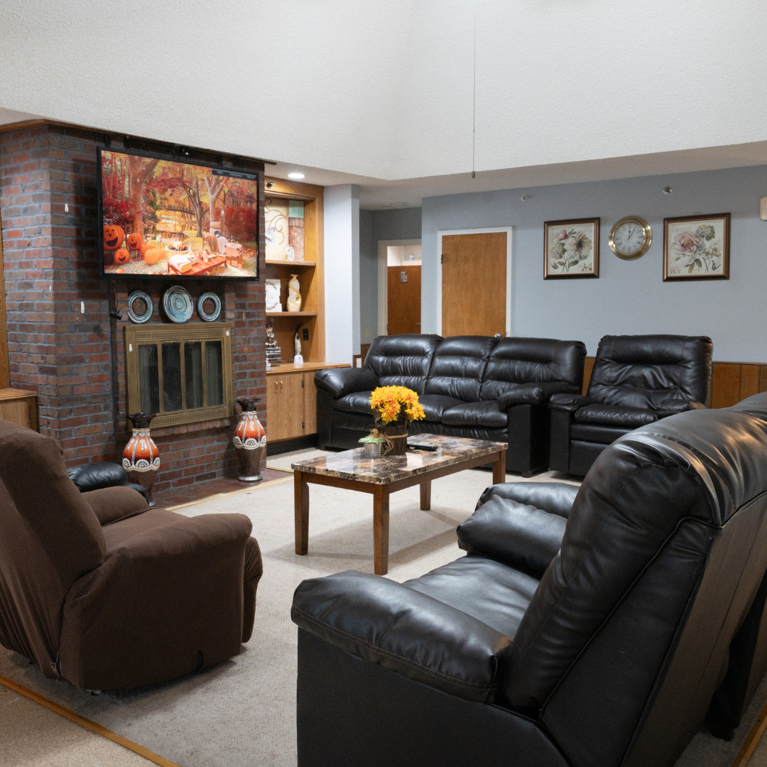 Living room with a fireplace, TV, couches, and chairs.