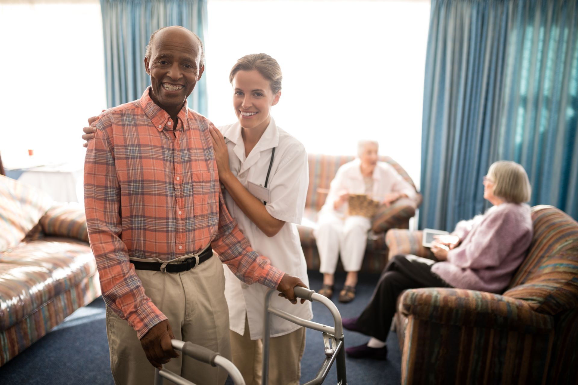 A nurse is helping an elderly man with a walker in a living room.