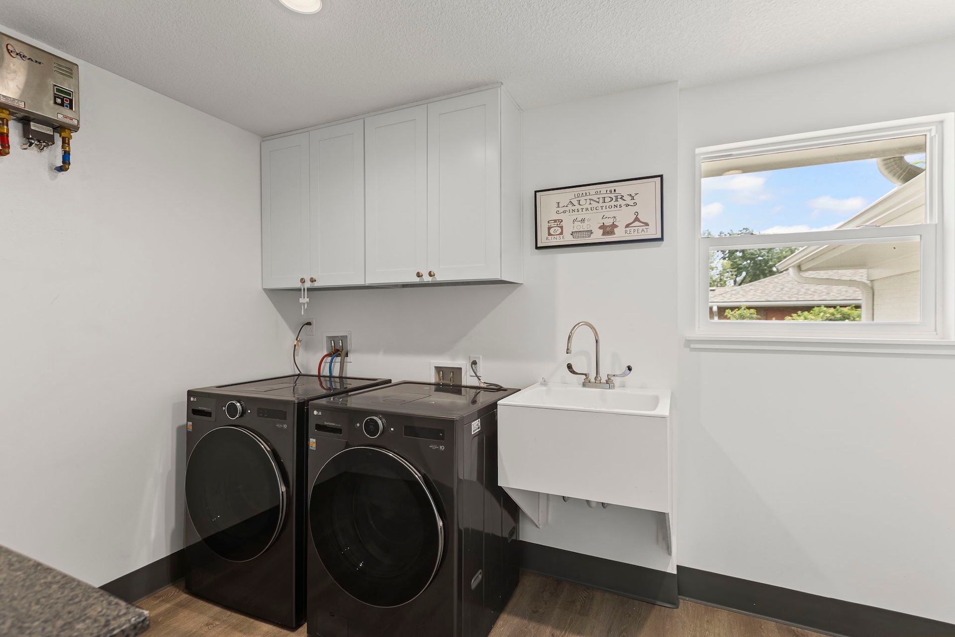 A laundry room with a washer and dryer and a sink.