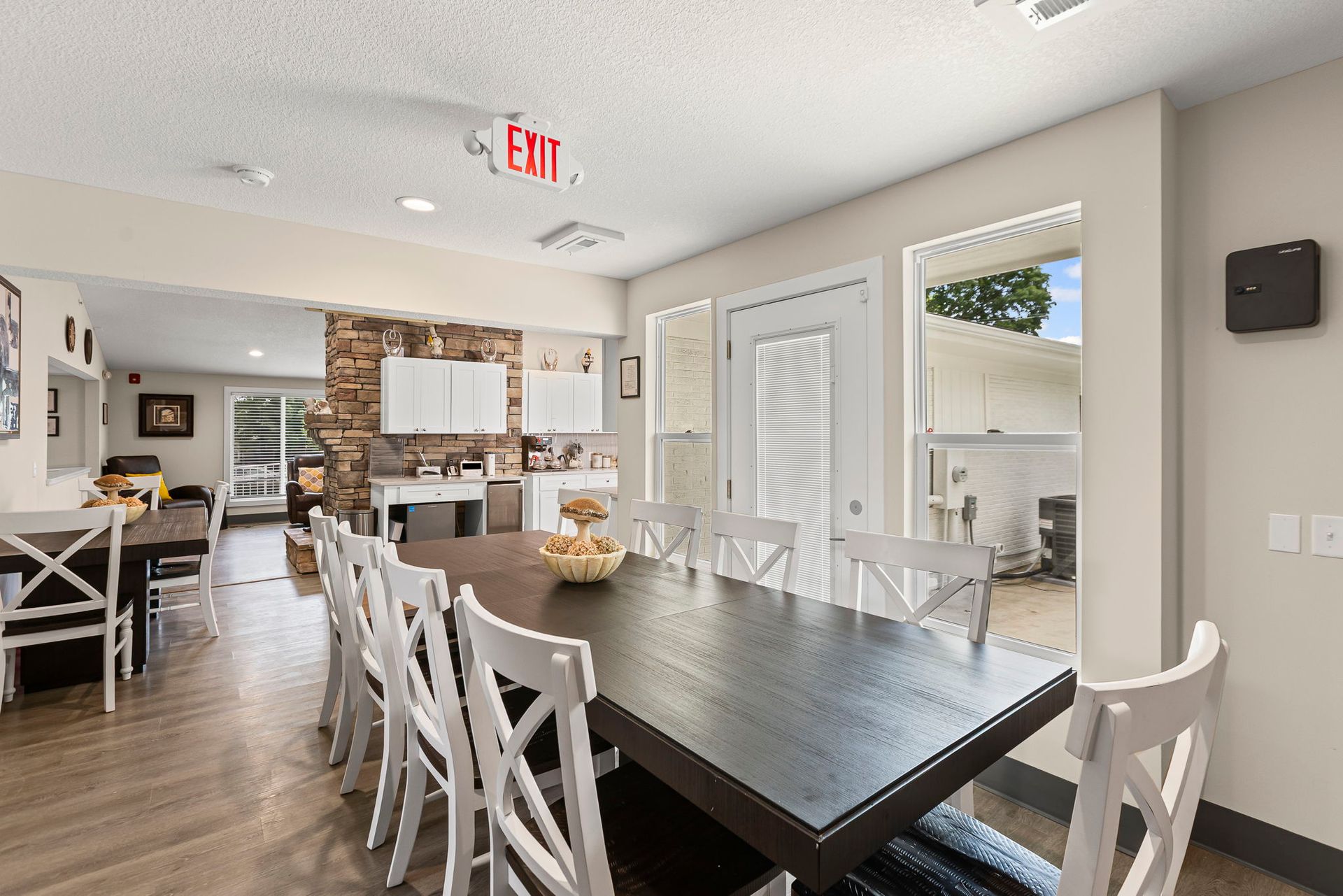 A dining room with a long table and white chairs.