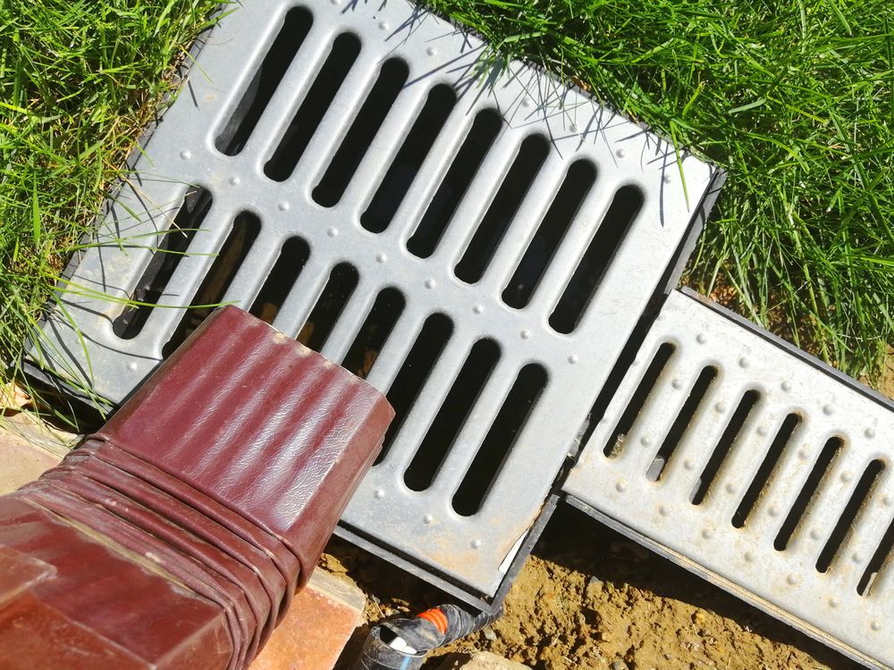 Una persona con traje señala con un bolígrafo documentos financieros, una calculadora y una computadora portátil en el escritorio.