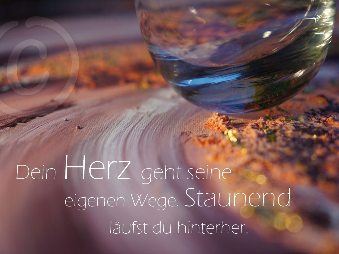 Eine dynamische Herzform in Gold un Rot auf blauem Untergrund