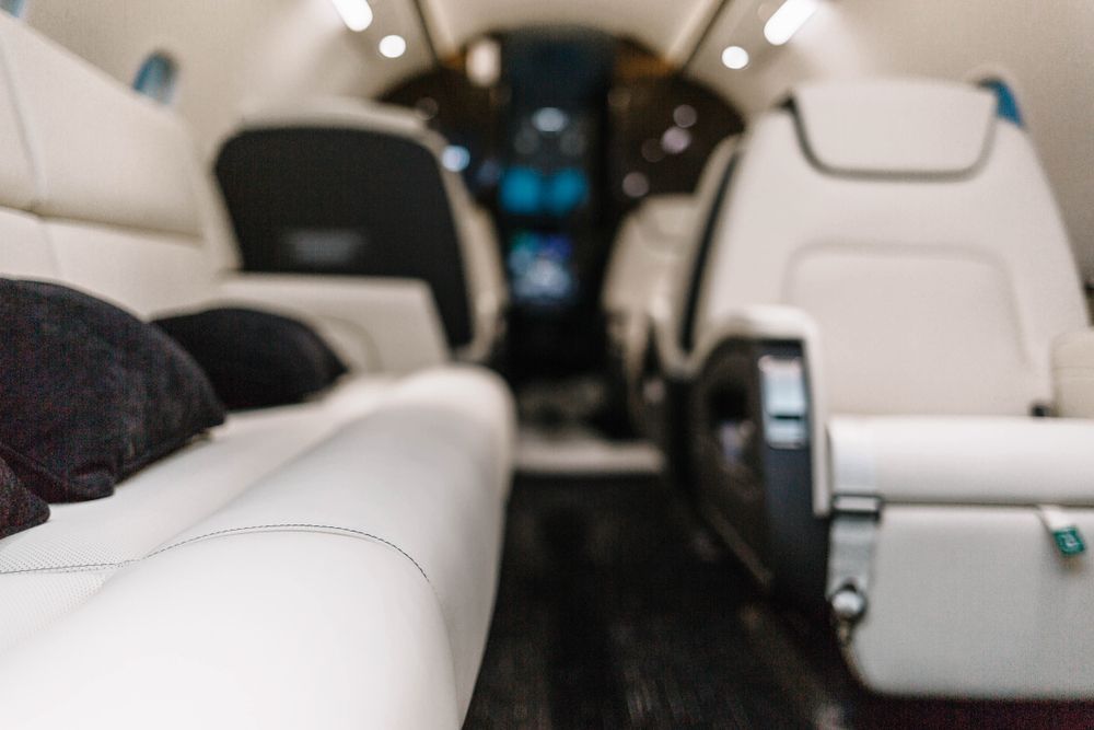 The inside of a private jet with a lot of seats and a couch.