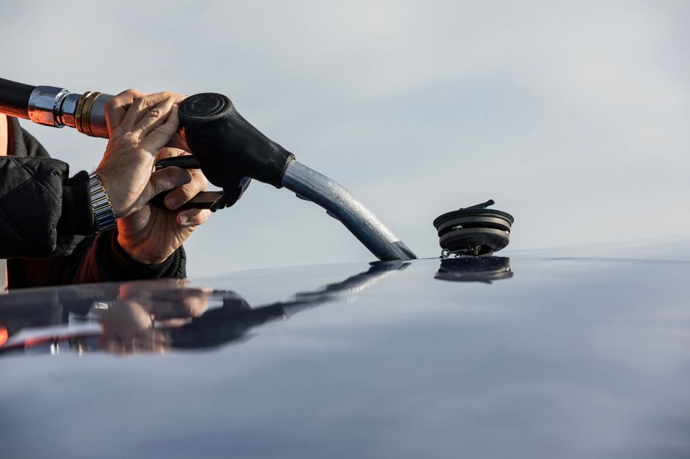 A man is refueling a jet with a hose.