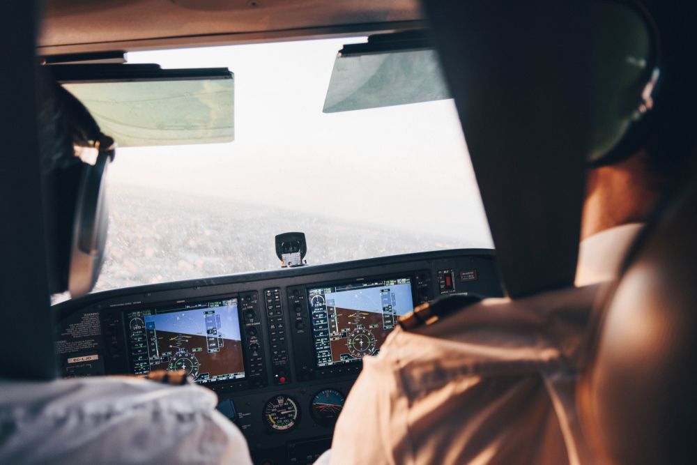 A pilot is sitting in the cockpit of an airplane.