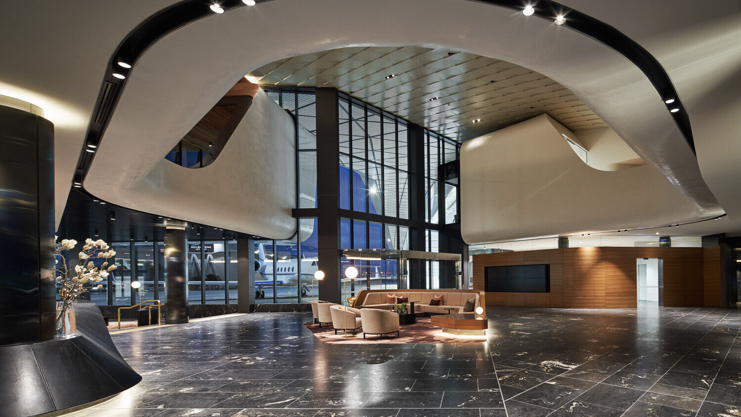 A large lobby with a curved ceiling and a lot of windows