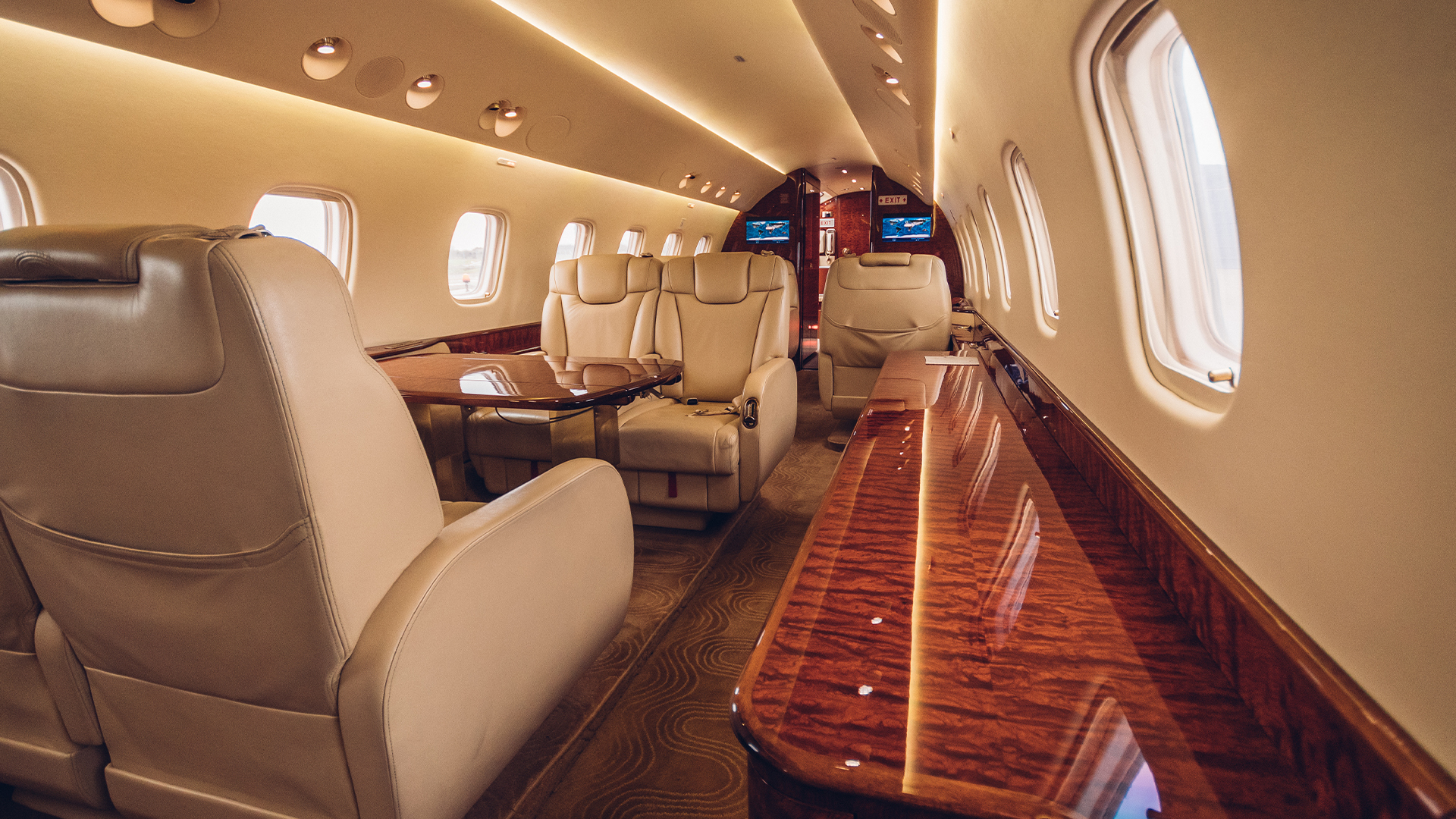 The inside of a private jet with a table and chairs.