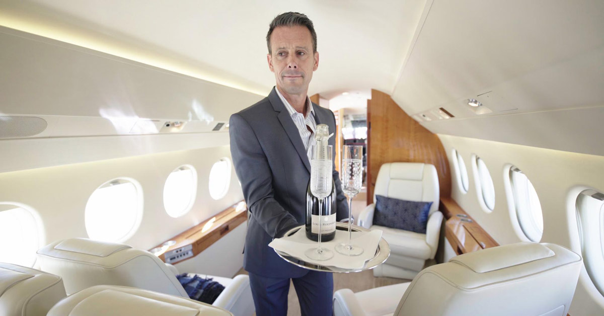 Professional private jet crew welcoming VIP guests at an Australian airport, ready for charter flights.
