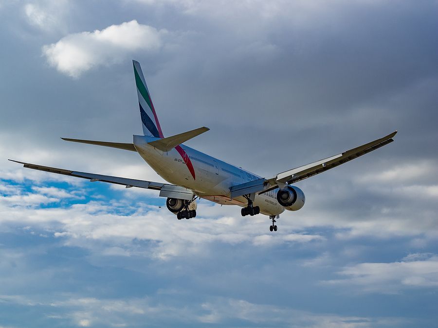 a large jetliner flying through a cloudy blue sky