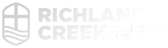The logo for richland creek is gray and has a shield on it.