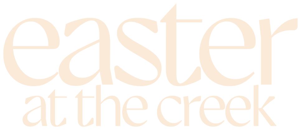 The logo for christmas at the creek is gold on a white background.