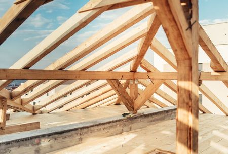 A Wooden Roof Is Being Built on Top of A Building  — Trussted Frames & Trusses in Bennetts Green, NSW