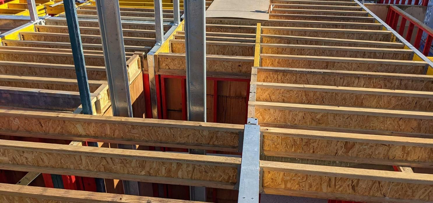A Construction Site with A Lot of Wooden Beams and Scaffolding — Trussted Frames & Trusses in Bennetts Green, NSW