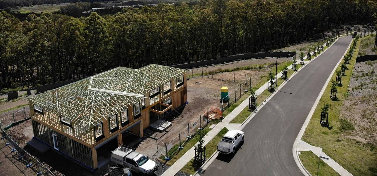 An Aerial View of A House Under Construction Next to A Road — Trussted Frames Trusses in Bennetts Green, NSW