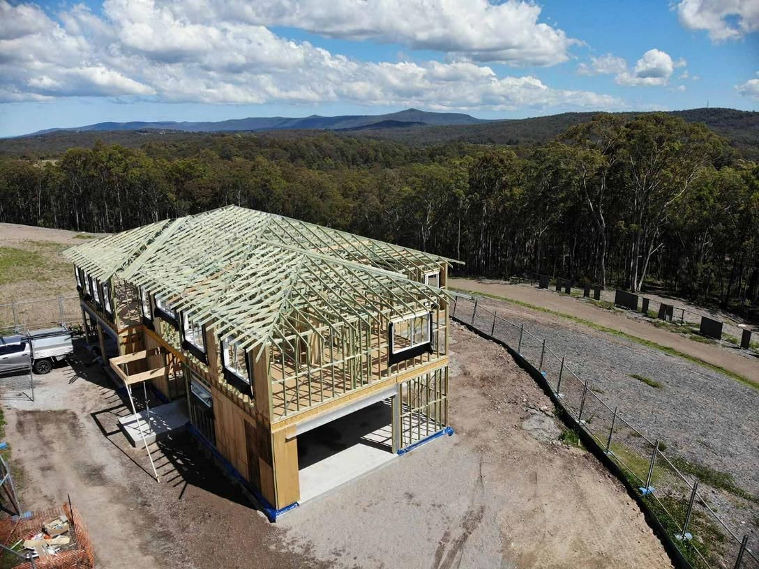 An Aerial View of A House Under Construction in The Middle of A Forest — Trussted Frames Trusses in Bennetts Green, NSW