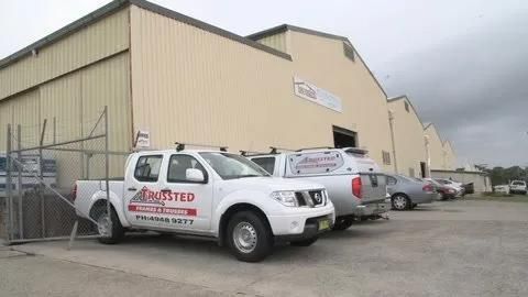 A Row of Trucks Are Parked in Front of A Building — Trussted Frames Trusses in Bennetts Green, NSW