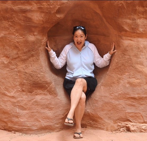 Felicia sitting on a rock with her legs crossed