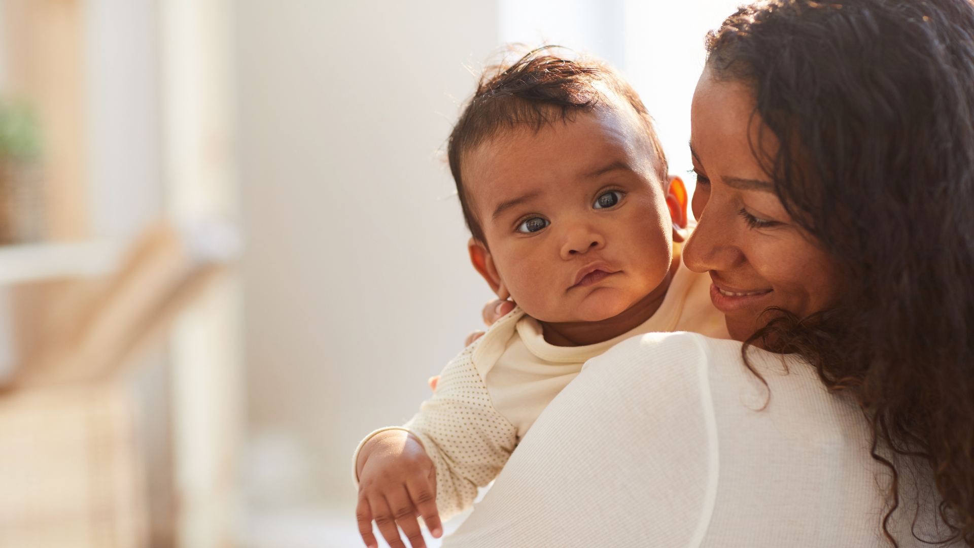 A woman is holding a baby in her arms.
