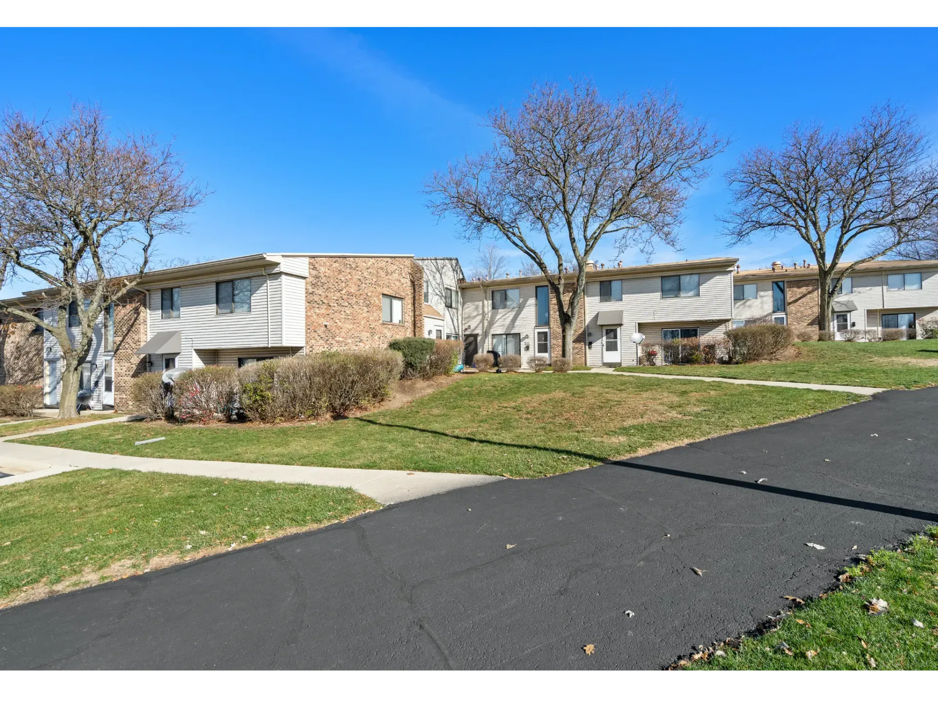 Exterior view of apartment buildings surrounded by grass and trees