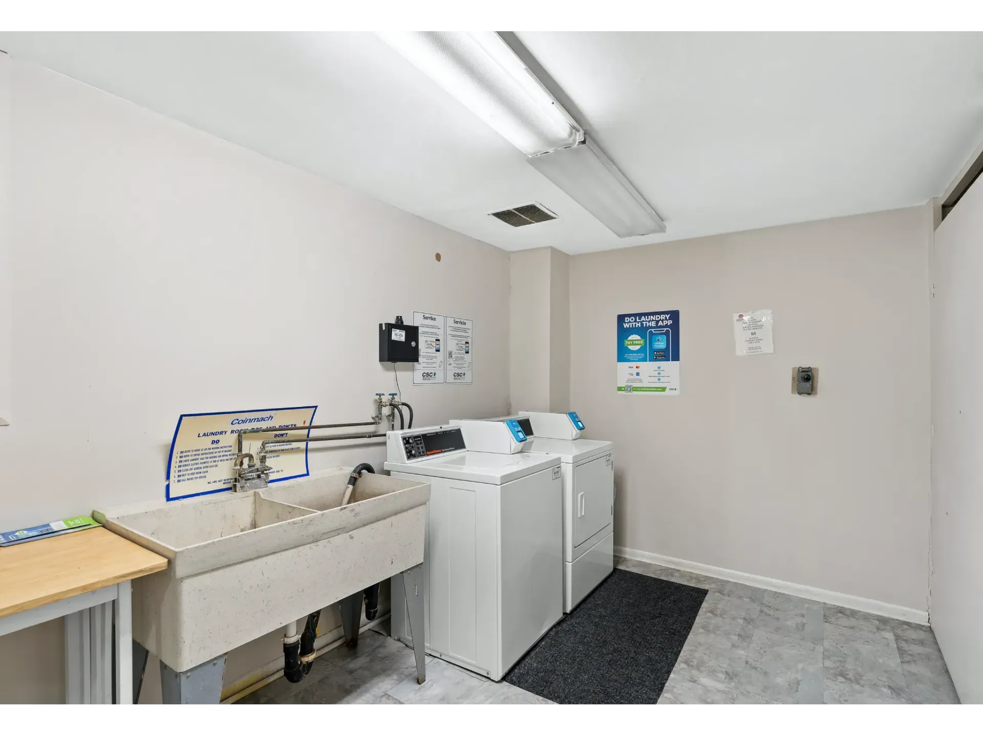 Laundry room with washers, dryer, and utility sink.