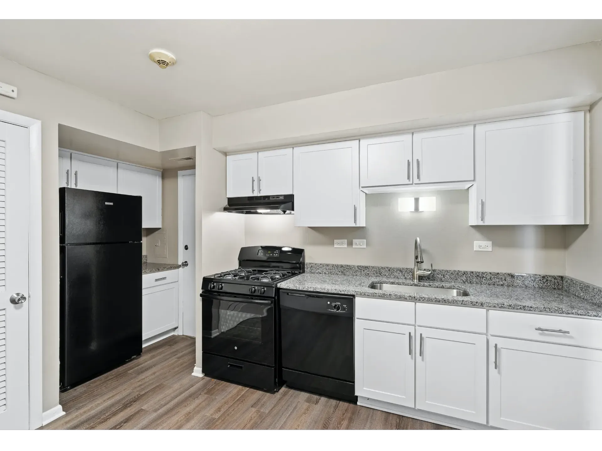 Modern kitchen featuring black appliances and white cabinets