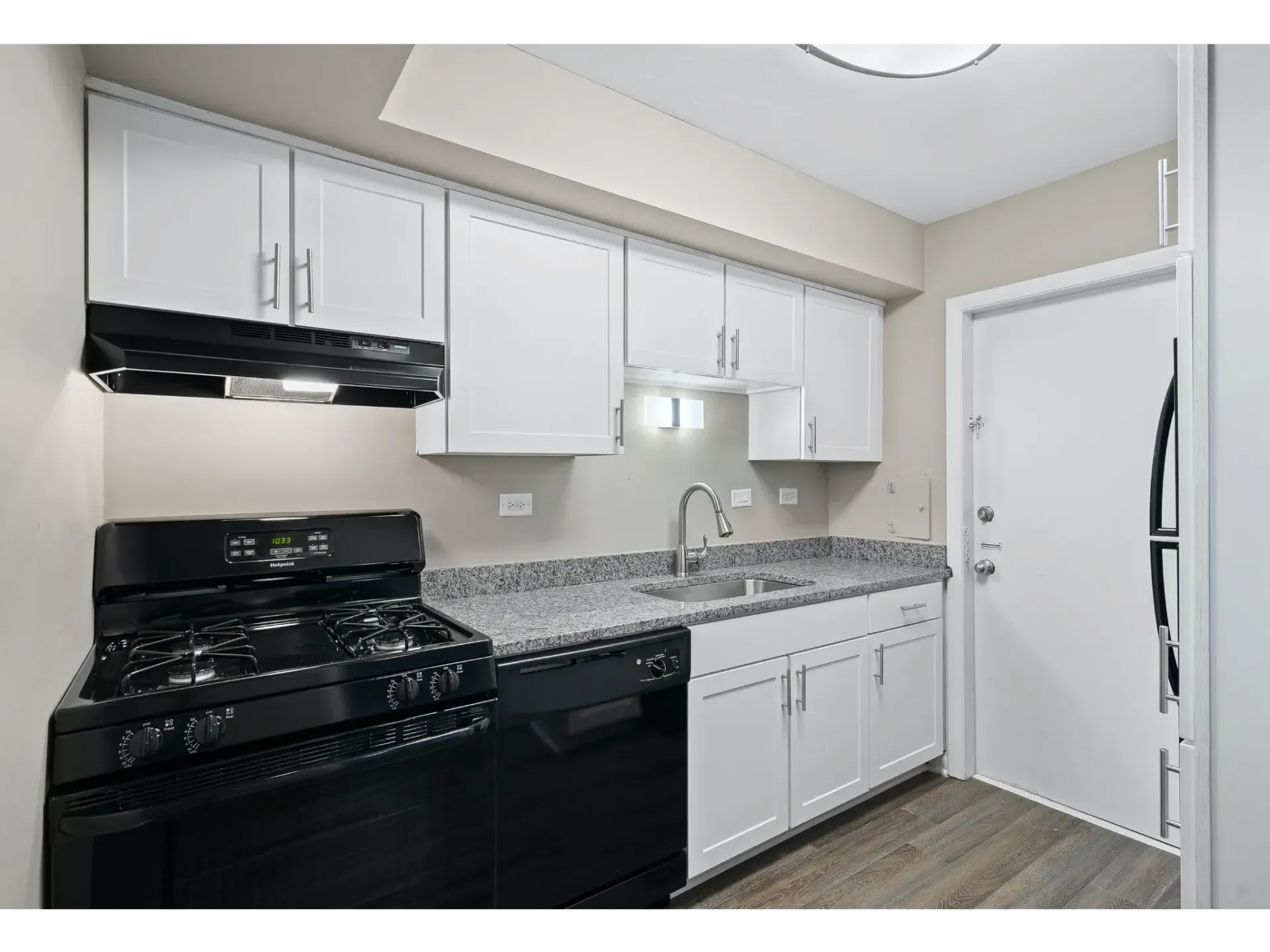 Modern kitchen with white cabinets and black appliances