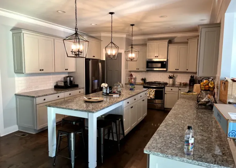 Bedroom with built-in gray cabinets over and around a bed with pink bedding.