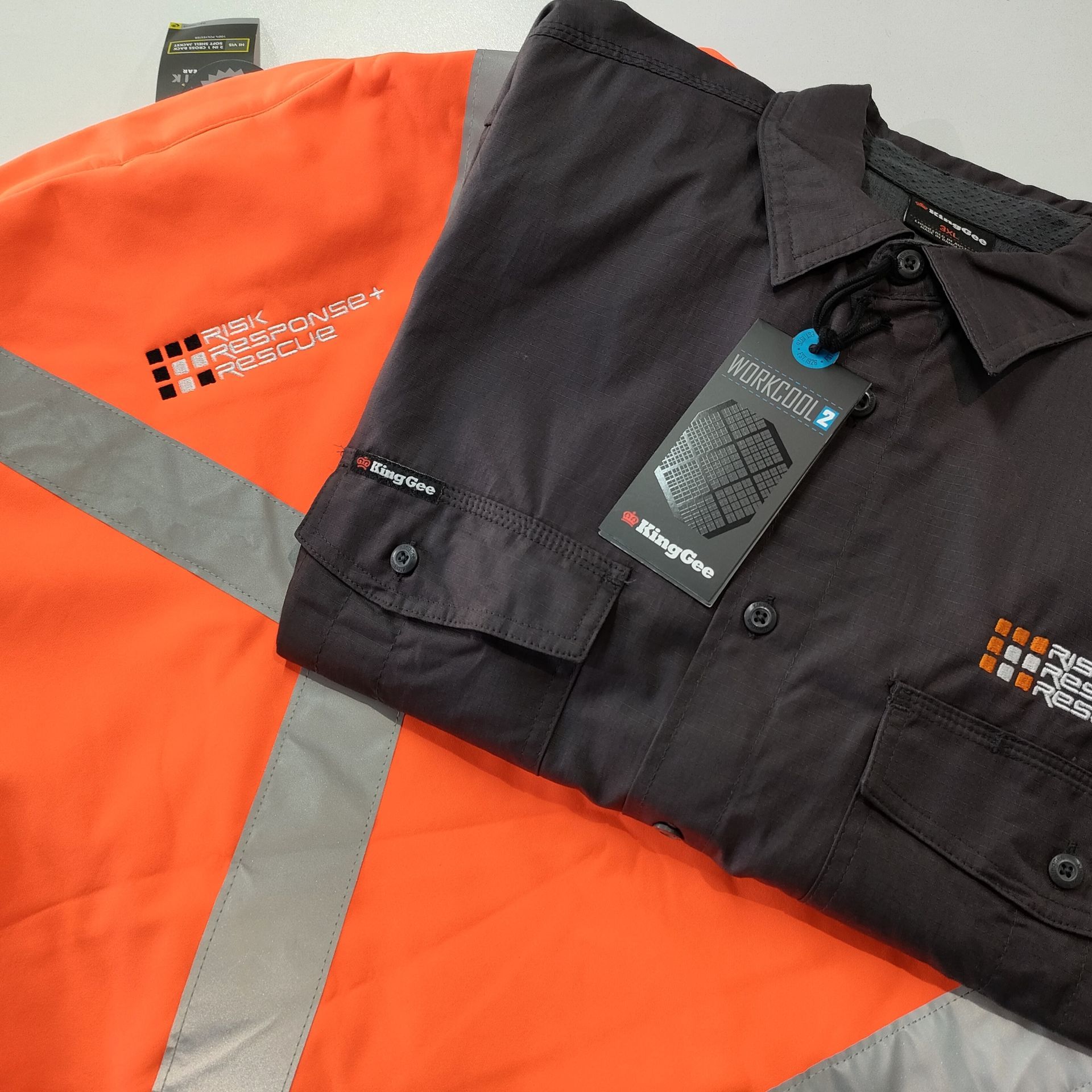 A Close Up Of Orange Hi Vis Jacket And Black Button Up Shirt — NMTG Embroidery In Wollongong, NSW