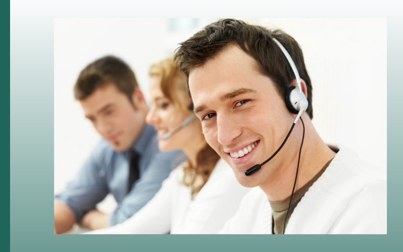 Smiling headset support agent in call center with coworkers blurred in background