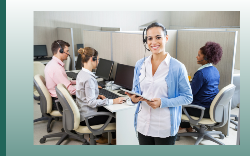 Office team in a meeting, with a woman in a blue cardigan speaking into a headset.