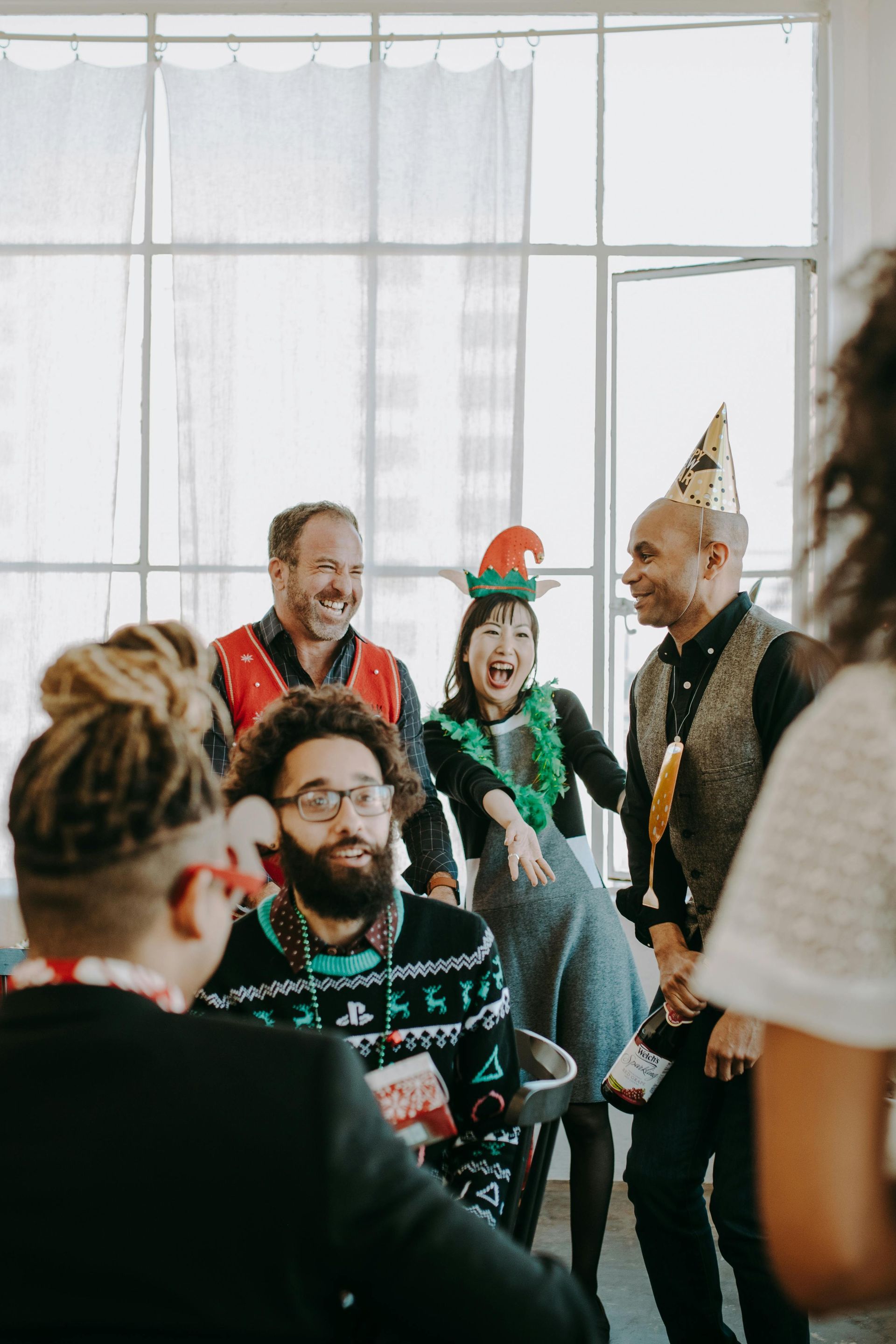 A group of people are standing around a table at a christmas party.