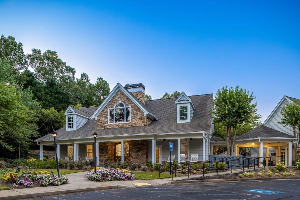 Exterior view of the clubhouse with a large porch at Marquis at Sugarloaf in Duluth, GA.