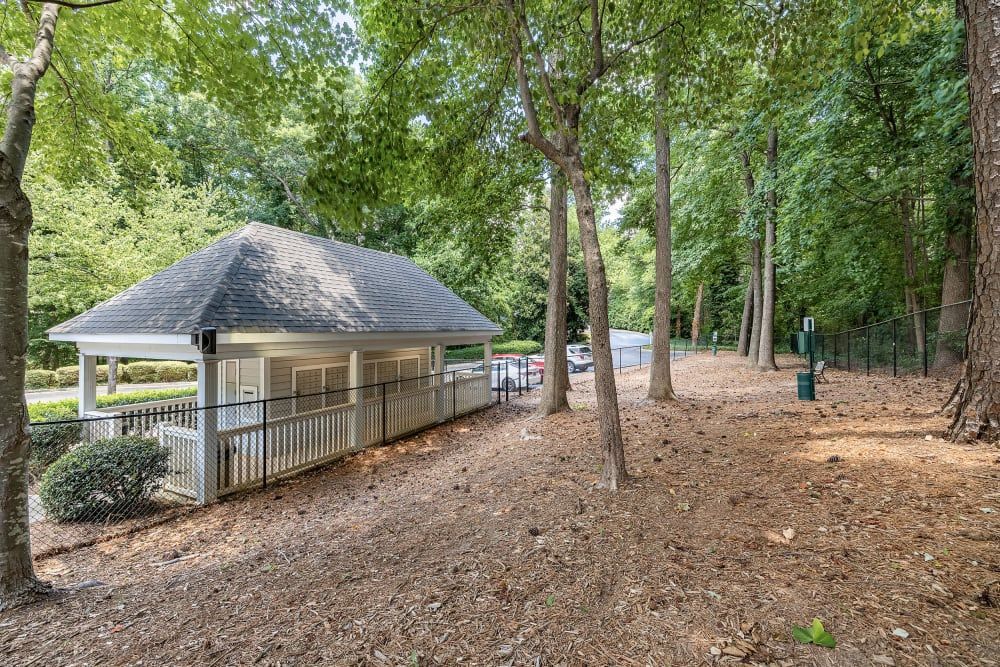 Pavilion with white railing and roof in a wooded area; car parked in the background at Marquis at Sugarloaf, offers apartments near Sugarloaf Mills.