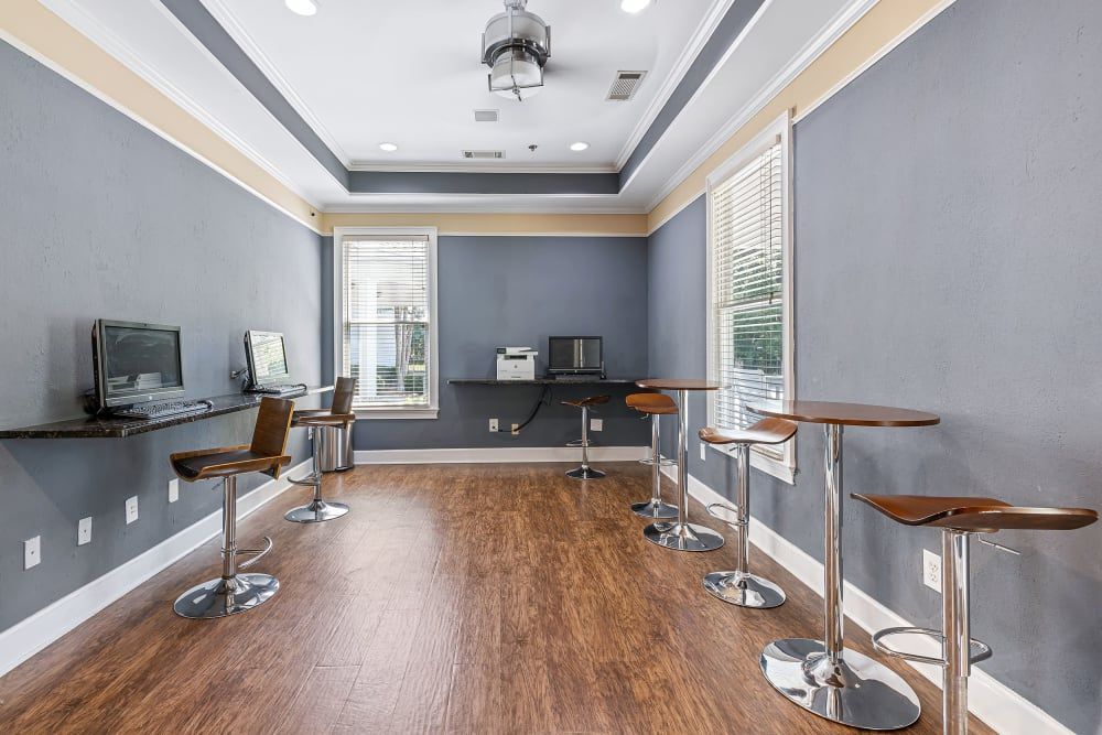 Business center with wooden floors, tables, chairs and computers at Marquis at Sugarloaf in Duluth, GA.